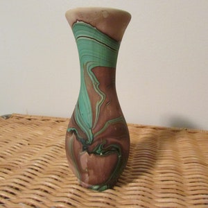 Può includere: Un piccolo vaso in ceramica marrone e verde con un design marmoreo. Il vaso ha un collo stretto e un corpo arrotondato.