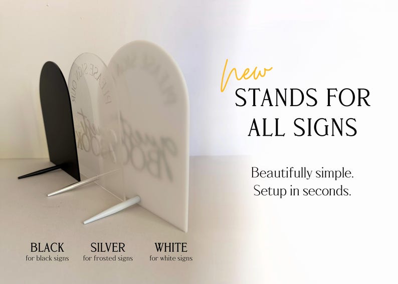 May include: Three arched acrylic signs in black, frosted, and white, each supported by a matching stand. Text on the image reads: New STANDS FOR ALL SIGNS. Beautifully simple. Setup in seconds. BLACK for black signs, SILVER for frosted signs, WHITE for white signs.