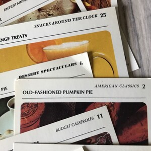 May include: Close-up of recipe cards with titles like "Butterscotch Rounds", "Entertaining on a Shoestring", "Snacks Around the Clock", "Dessert Spectaculars", "Old-Fashioned Pumpkin Pie", "American Classics", "Budget Casseroles", "Steak Kabobs", "Outdoor Entertaining", and "National Favorites".