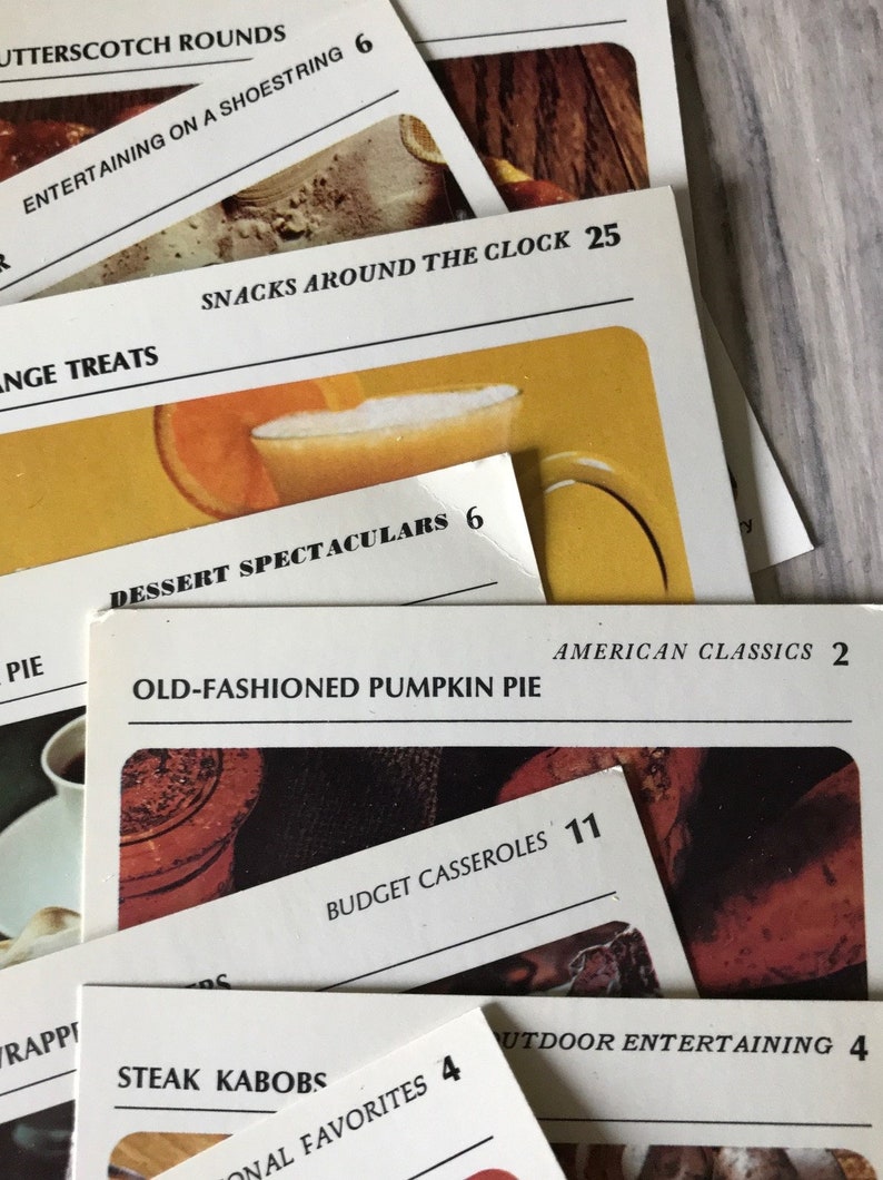 May include: Close-up of recipe cards with titles like "Butterscotch Rounds", "Entertaining on a Shoestring", "Snacks Around the Clock", "Dessert Spectaculars", "Old-Fashioned Pumpkin Pie", "American Classics", "Budget Casseroles", "Steak Kabobs", "Outdoor Entertaining", and "National Favorites".