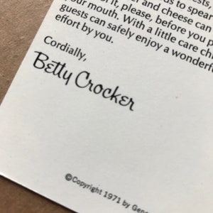 May include: A close-up of a white card with black text. The text reads "Cordially, Betty Crocker" and "Copyright 1971 by General Mills, Inc. All rights reserved."