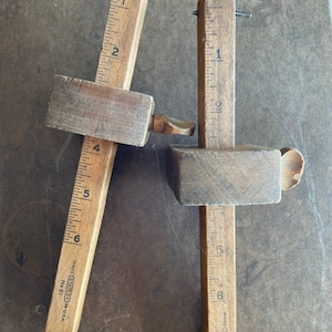 May include: Two vintage wooden measuring tools with metal points and markings in inches. The tools are made by Stanley and are labeled "No. 61" and "Made in USA".