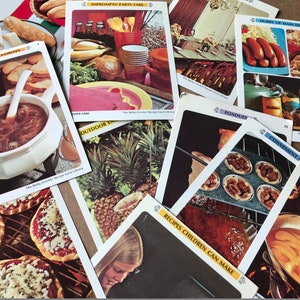 May include: A collection of recipe cards featuring various dishes, including onion soup, pizza, pineapple, and a variety of desserts. The cards are from "The Betty Crocker Recipe Card Library" and feature different categories like "International Favorites", "Impromptu Party Fare", "Hunky Up Main Dishes", "Fondues", "Convenient", "Outdoor", and "Recipes Children Can Make".