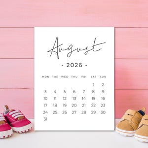 May include: A white calendar print for August 2026, with the month name in elegant script. The calendar grid is in a simple, clean font. The image includes a pair of pink and a pair of tan baby shoes, suggesting a baby-themed product.