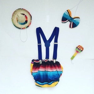 K&ouml;nnte beinhalten: Ein farbenfrohes Baby-Outfit mit Sombrero, Fliege, Hosentr&auml;gern und Maracas. Das Outfit ist perfekt f&uuml;r eine Fiesta-Mottoparty.