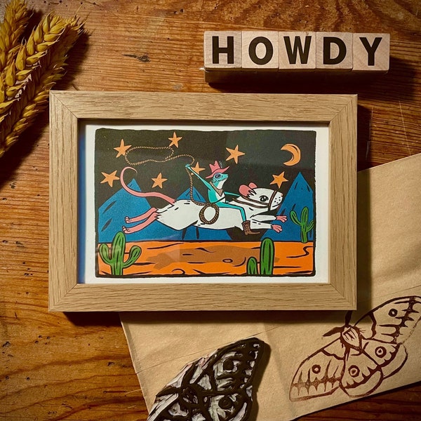 Stampa incorniciata raffigurante una rana cowboy che cavalca un topo - pronta da appendere, stampa murale da 4"x6" con una rana da rodeo colorata, divertente e stravagante che indossa un cappello da cowboy.