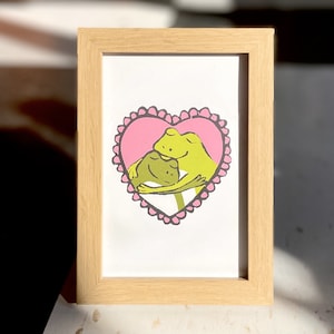 Grenouilles en forme de coeur câlins - Cadre en option 4 x 6 po, art mural/carte de grenouilles amoureuses, cadeau de la Saint-Valentin pour un ami, un partenaire, une fête prénatale