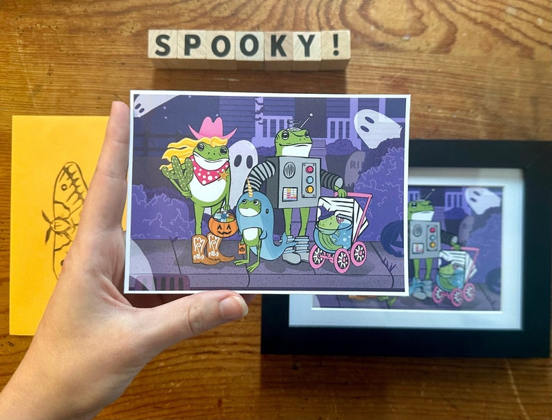 K&ouml;nnte beinhalten: Eine Halloween-Illustration mit f&uuml;nf Fr&ouml;schen in Kost&uuml;men. Die Fr&ouml;sche tragen einen Cowboyhut, ein Roboterkost&uuml;m, ein Einhornkost&uuml;m und zwei sind in Kinderwagen. Die Illustration spielt vor einem violetten Hintergrund mit einem Geist und einem Spukhaus.