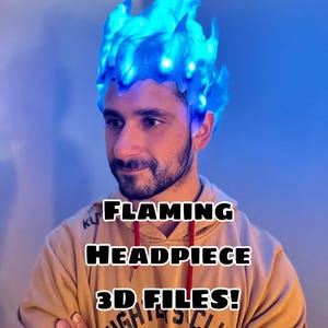 May include: A blue, flame-shaped headpiece with embedded lights. The headpiece is worn on the head. The image includes the text "FLAMING HEADPIECE 3D FILES!"
