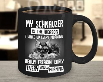 May include: Black coffee mug with white text that reads "My Schnauzer is the reason I wake up every morning really freakin' early every single morning". A black and white image of a Schnauzer dog is in the center of the mug.