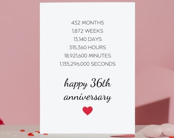 Puede incluir: Una tarjeta blanca con texto negro que dice "432 MESES, 1.872 SEMANAS, 13.140 DÍAS, 315.360 HORAS, 18.921.600 MINUTOS, 1.135.296.000 SEGUNDOS, feliz 36 aniversario". Un pequeño corazón rojo está en la parte inferior de la tarjeta. La tarjeta está sobre una superficie rayada rosa y blanca.