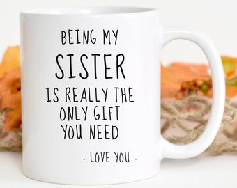 May include: White ceramic mug with black text that reads "Being my sister is really the only gift you need - Love you -"