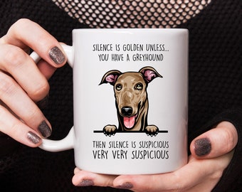 May include: White ceramic mug with a brown and white illustration of a Greyhound dog peeking over the top. The mug has the text "Silence is golden unless... you have a Greyhound. Then silence is suspicious. Very very suspicious."