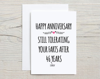 May include: White card with black text that reads "Happy Anniversary Still Tolerating Your Farts After 46 Years" with a pink heart and gray floral design.