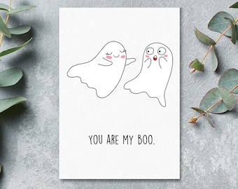May include: A white card with two cartoon ghosts. The ghost on the left is smiling and waving. The ghost on the right is surprised with its mouth open. The text "YOU ARE MY BOO." is printed below the ghosts.