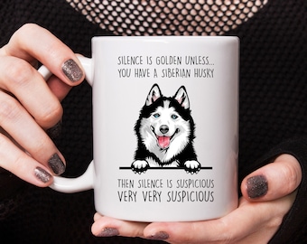 May include: White ceramic mug with a black and white illustration of a Siberian Husky peeking over the top. The text on the mug reads "Silence is golden unless... you have a Siberian Husky. Then silence is suspicious very very suspicious."