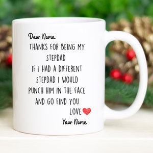 May include: White ceramic mug with a black and red message that reads "Dear Name, THANKS FOR BEING MY STEPDAD IF I HAD A DIFFERENT STEPDAD I WOULD PUNCH HIM IN THE FACE AND GO FIND YOU LOVE Your Name".