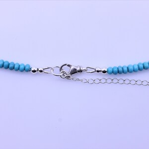 May include: A turquoise beaded necklace with a silver clasp and extender chain.