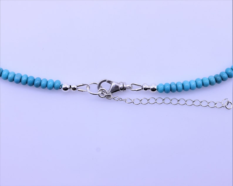 May include: A turquoise beaded necklace with a silver clasp and extender chain.