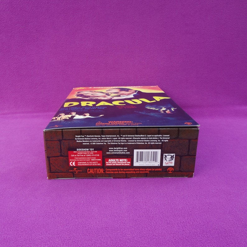 May include: A rectangular box featuring the title "DRACULA" in large, stylized letters. The box has a brick-like pattern on the sides and a movie poster design on the top, with images of characters and the film's title.