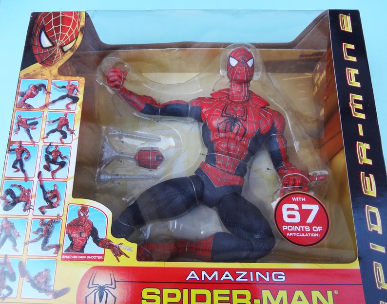 Puede incluir: Figura de acci&oacute;n de Amazing Spider-Man en una vitrina de pl&aacute;stico transparente. La figura es roja y negra con un emblema de ara&ntilde;a en el pecho. El embalaje incluye el texto "WITH 67 POINTS OF ARTICULATION!"