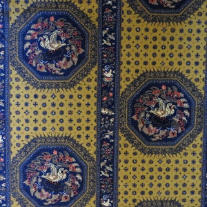 May include: A patterned fabric with a repeating design. The fabric features octagonal shapes with a bird and floral motif in navy blue and red, set against a mustard yellow background. Vertical navy blue stripes with bird and floral patterns border the octagons.