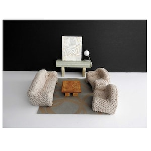 May include: A set of three ceramic mugs with a speckled, matte finish. The mugs are in shades of cream, light brown, and dark brown. Each mug has a simple, minimalist design and a rounded handle.