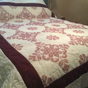 Hand embroidered quilt. Burgundy and white.