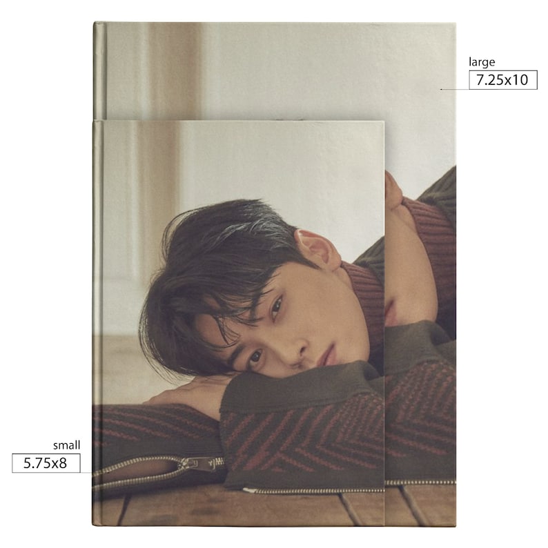 May include: A photo of a man with dark hair lying on a wooden floor. He is wearing a brown and red patterned sweater. The image is cropped to show the man's face and upper body. The text "small 5.75x8" is in the bottom left corner of the image. The text "large 7.25x10" is in the top right corner of the image.