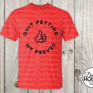 Può includere: Maglietta rossa con un grafico circolare nero che dice "Quit Petting My Peeves" con un gesto di pollice in su.