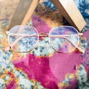 Puede incluir: Un letrero de madera hecho a mano con la palabra "Bienvenido" en estilo manuscrito. El letrero está pintado de blanco con un acabado envejecido, y una pequeña hoja verde está adjunta. El letrero mide unos 30 cm de ancho.