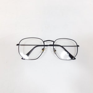 May include: Black square-shaped eyeglasses with clear lenses.