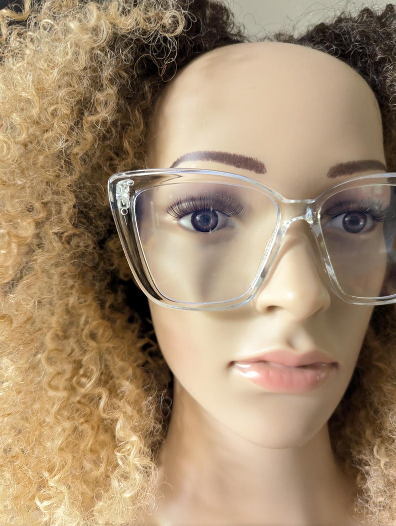 K&ouml;nnte beinhalten: Transparente Brille mit Kunststoffgestell in Katzenaugenform. Die Brille sitzt auf einem Mannequin-Kopf mit blonden Locken.
