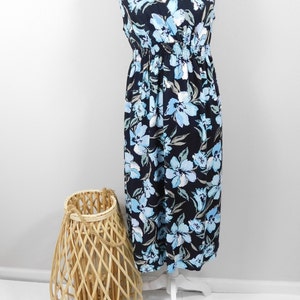 May include: A sleeveless maxi dress with a V-neckline and a floral print in shades of blue and white on a black background. The dress has a fitted bodice and a flowy skirt.
