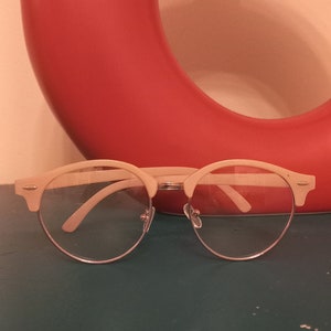 May include: White framed clear glasses with a red and white background.