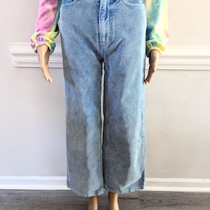 May include: Light blue wide-leg corduroy pants with a high waist and a straight leg.