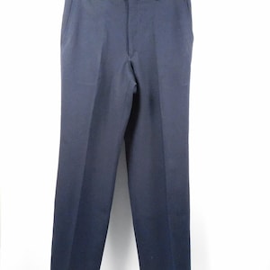 Peut inclure: Pantalon de costume bleu marine suspendu sur fond blanc. Le pantalon a une coupe classique à jambes droites avec une fermeture à bouton et fermeture éclair. Le pantalon est en tissu uni et lisse.