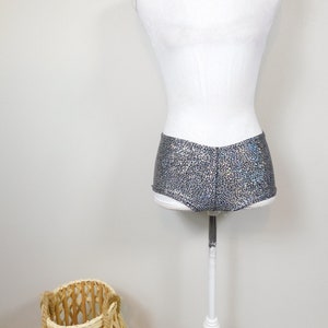 May include: Silver and black shimmery shorts with a textured pattern. The shorts are on a white mannequin.