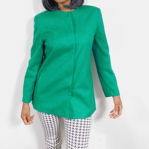 May include: A bright green blazer with a mandarin collar and a single button closure. The blazer has long sleeves and a straight hem.