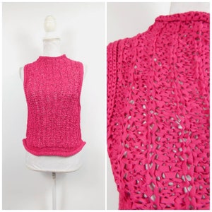 May include: A sleeveless, hot pink knit top with a high neckline. The top has a textured, open weave design. The garment is displayed on a white mannequin against a white background. A close-up shows the intricate weave.