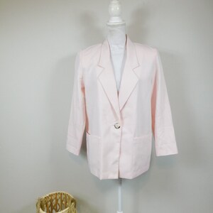 May include: A pale pink linen blazer with a single button fastening and two patch pockets.
