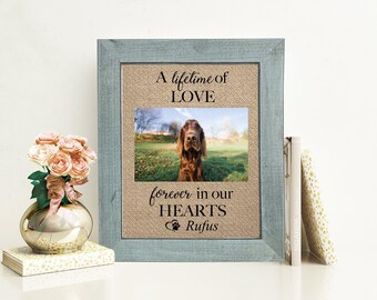 May include: A rectangular picture frame with a weathered blue-grey wood finish containing a burlap-textured mat. The mat features the black text A lifetime of LOVE, forever in our HEARTS, and the name Rufus with a paw print icon above a dog photo.