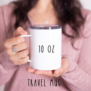 May include: White travel mug with a black inscription that reads "10 oz TRAVEL MUG".