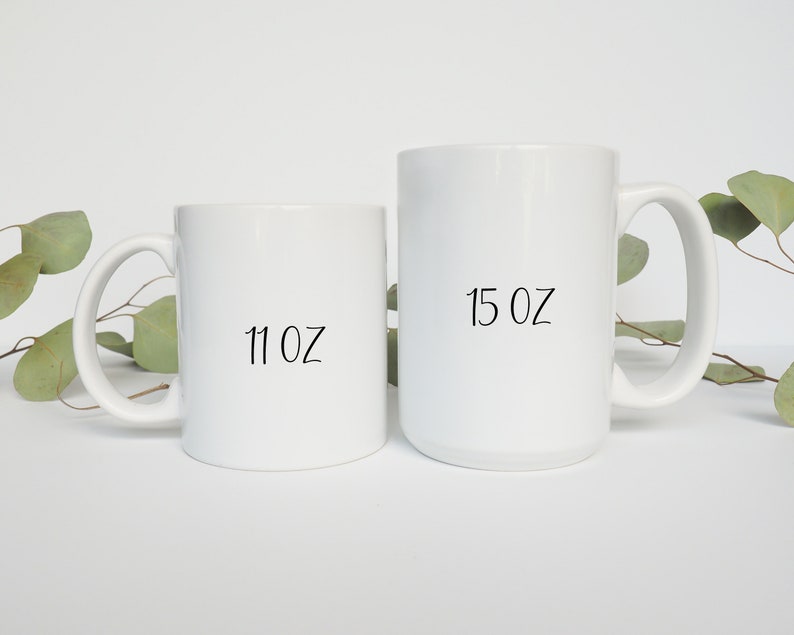 May include: Two white ceramic mugs with black text. The smaller mug is 11 oz and the larger mug is 15 oz.