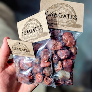 May include: Three bags of red jasper stones, each bag labeled with the text "LSAGATES".