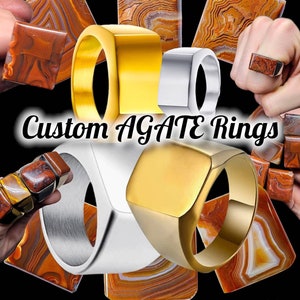 May include: Custom agate rings in gold, silver, and stainless steel. The rings feature a square-shaped agate stone with a unique pattern of brown, orange, and white.