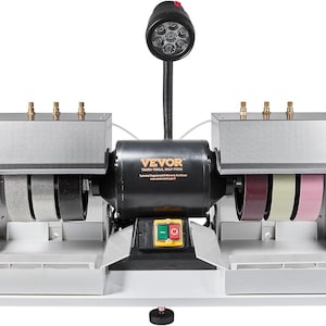 Puede incluir: Una amoladora de banco VEVOR con una carcasa de motor negra y componentes plateados. La amoladora tiene dos muelas, una lámpara de trabajo y un interruptor de encendido. El texto "VEVOR" es visible.