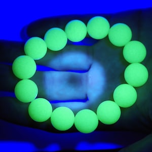 Puede incluir: Un brazalete hecho de cuentas de color verde brillante que brillan en la oscuridad.