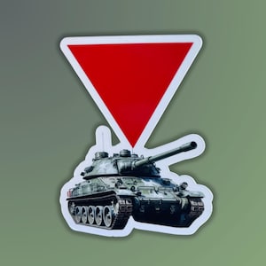 Puede incluir: Un tanque verde de camuflaje con una pegatina triangular roja en la parte superior. El tanque tiene un cañón grande y orugas.