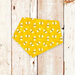 May include: Yellow fabric dog bandana with a pattern of black and white bees.